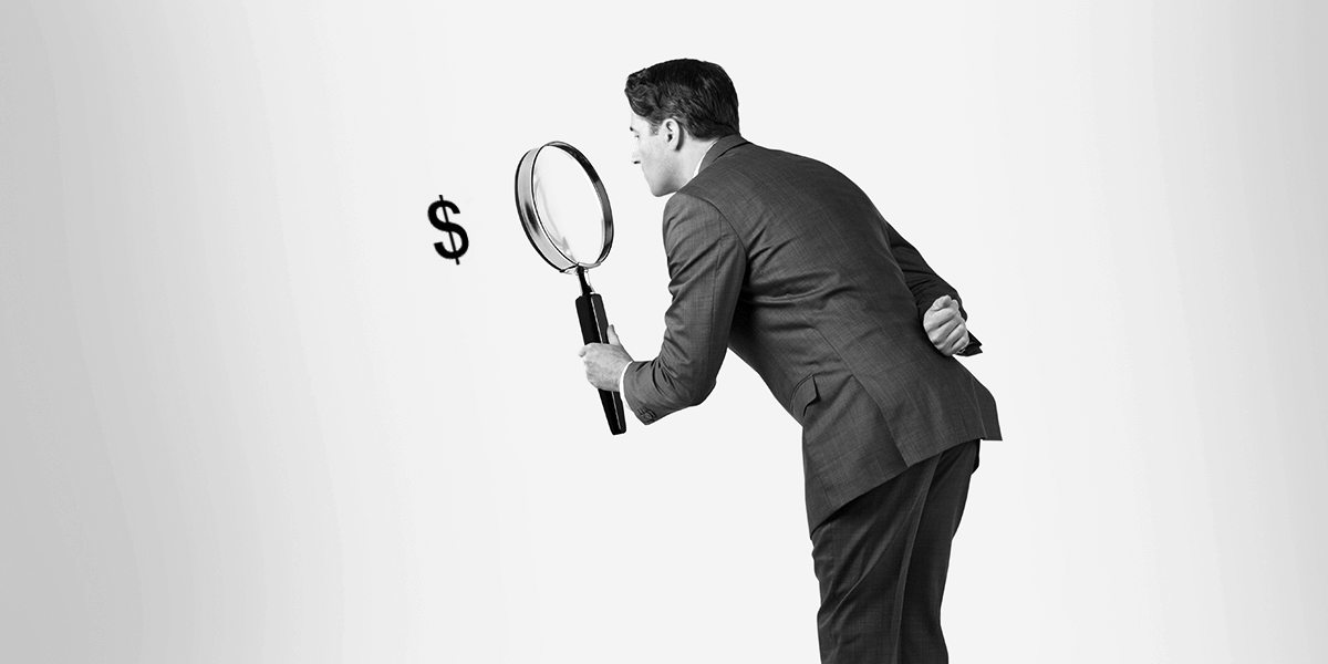 Man examining a dollar sign with an exaggeratedly large magnifying glass
