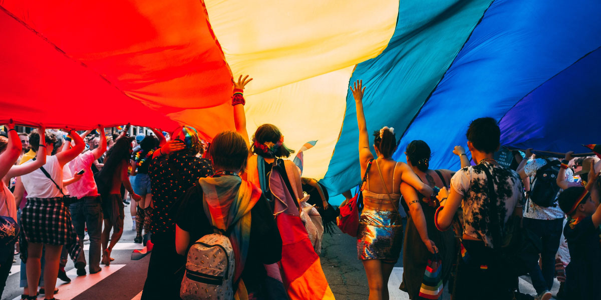 People under a rainbow parachute