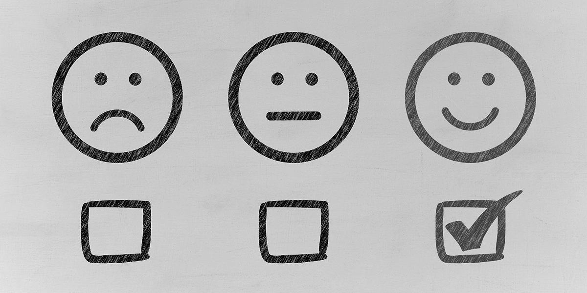 A frowning face, expressionless face, and a smiley face each with a checkbox below. The smiley face is checked.